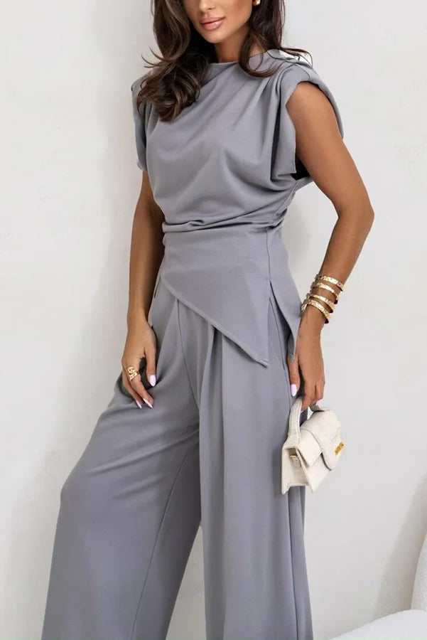 Tweedelige damesset bestaande uit een asymmetrische top en een broek met wijde pijpen